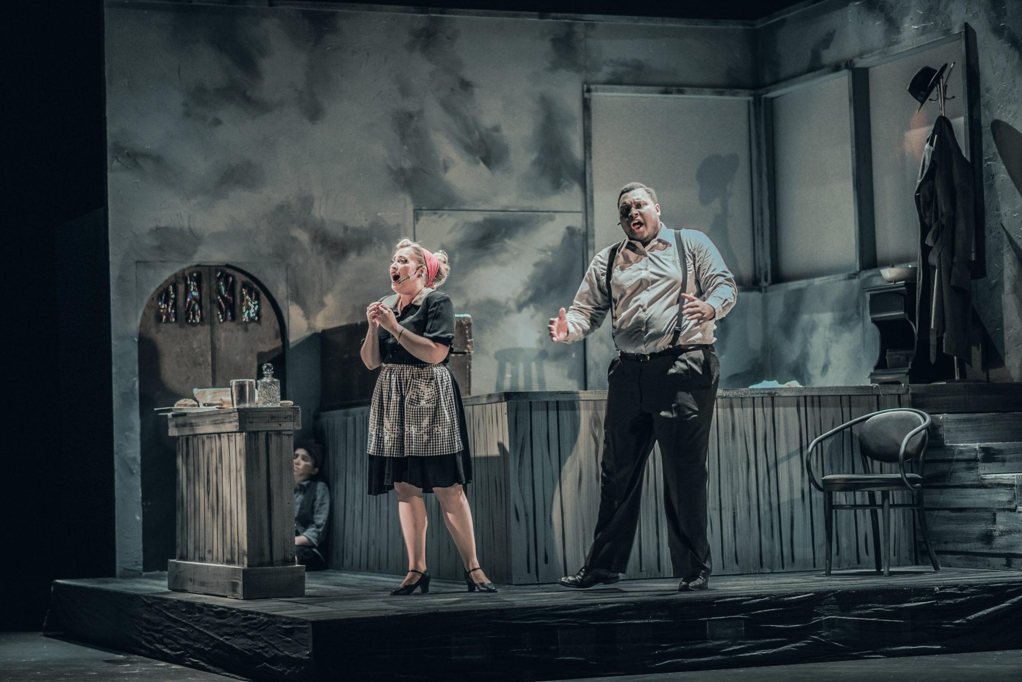 Two students singing on stage during a performance of Sweeney Todd
